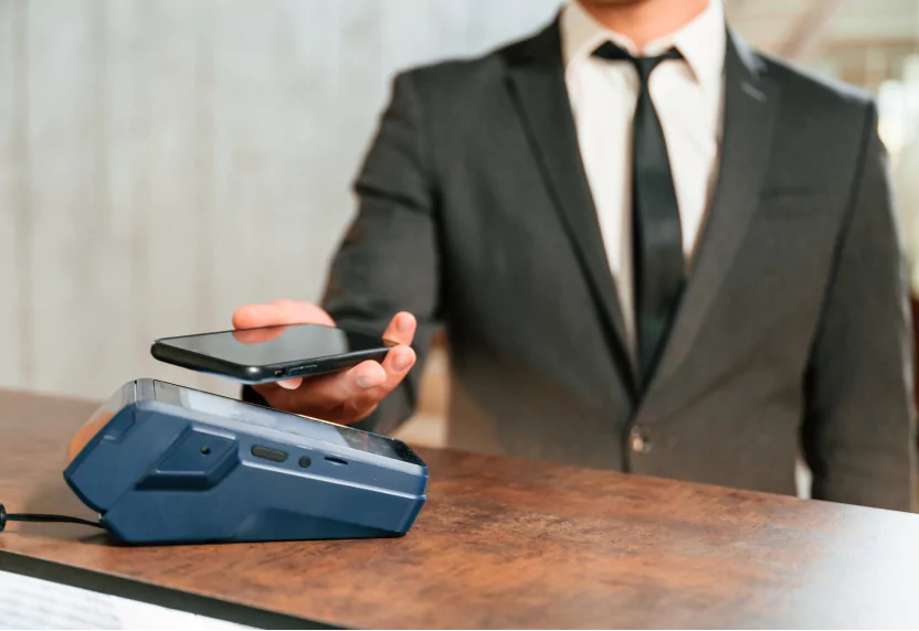 Customer paying contactlessly with a phone using NFC on a POS terminal.